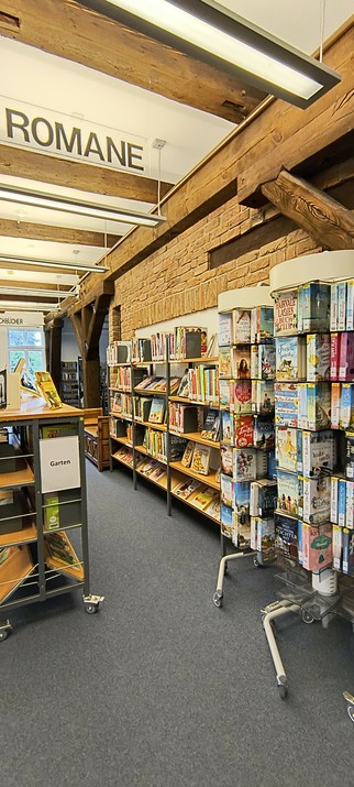 De afdeling romans (Romane) met een stenen muur en vakwerkbalken en veel boeken.