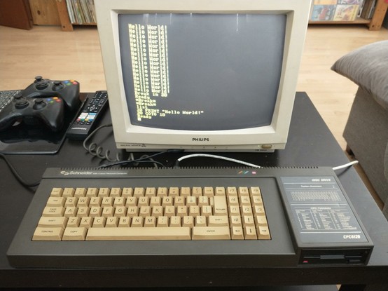 an Amstrad CPC6128 microcomputer connected to a Philips CM-8802 RGB color monitor, showing yellow text on black background.