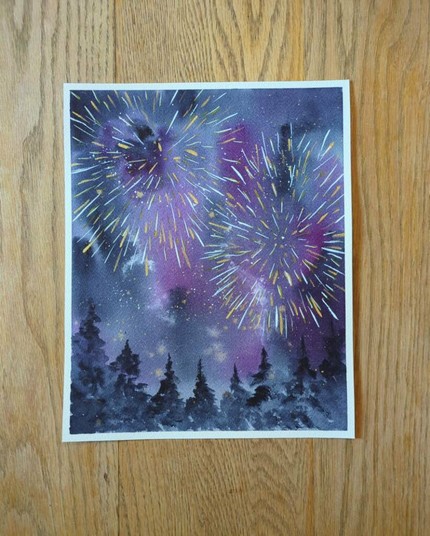 This is a watercolor painting of two fireworks in the night sky above some evergreen trees. It's painted in portrait orientation. The sky is varying shades and values of indigo and purple. The trees are varying values of indigo. The fireworks are streaks and spatters of white and gold.