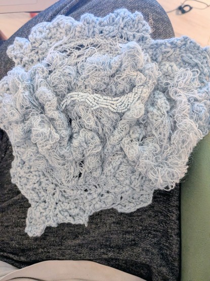 Pièce d'art textile au crochet reproduisant une plaque de lichen / des textures organiques pseudo-végétales sur laquelle sont brodées au centre des perles rocailles fines du même bleu clair que les fils
