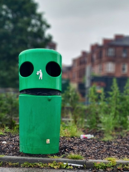 A bin with the lid slightly raised, making it look like a talking face.