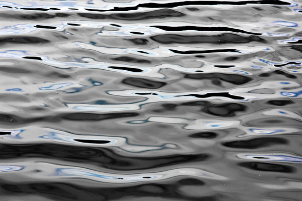 Wind-rippled water, white (from sun and clouds) with black and here and there some blue.