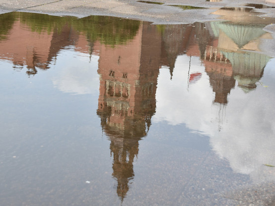Reflection of historic XVIII century buildings in a pond after the rain