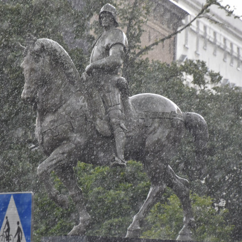 Statue of a man on a horse during a heavy rainfall