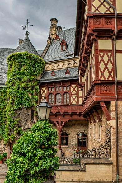 Fachwerk Fassaden im Innenhof des Schlosses. Rote Fachwerk Balken und gelbe Fassade. Bewachsen mit Kletterpflanzen.