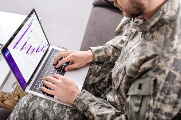 Person in military fatigues using Integrate software on a laptop