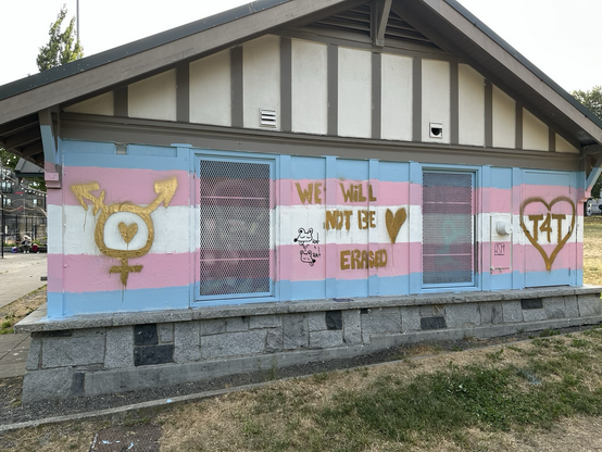 One of the cal Anderson sitting areas, painted with a trans flag and a message in gold that reads “we will not be erased”