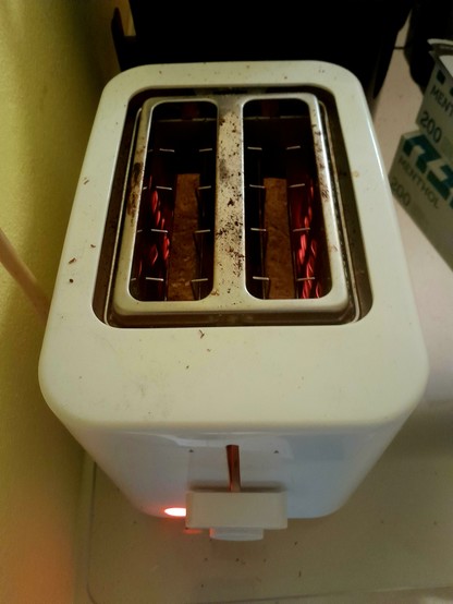 Filaments glow as toast toasts in the toaster, round side down.