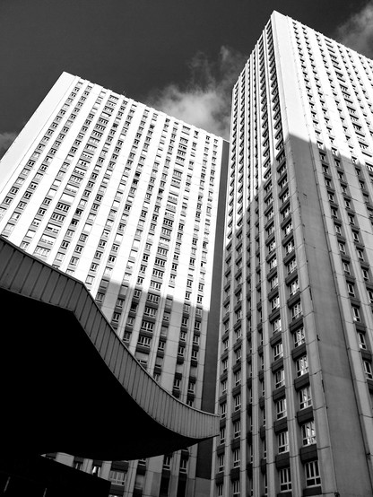 Building brutaliste dans le 13ème arrondissement de Paris, quartier asiatique. Une aile de pagode au bas de la photo monchrome en contre-plongée sur l'immeuble.