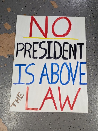 Other side of the protest sign that reads No President is Above the Law.