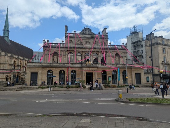 Photo of the exterior of the RWA gallery with a 1km long pink ribbon wrapped around the building.  Why - because its art.
