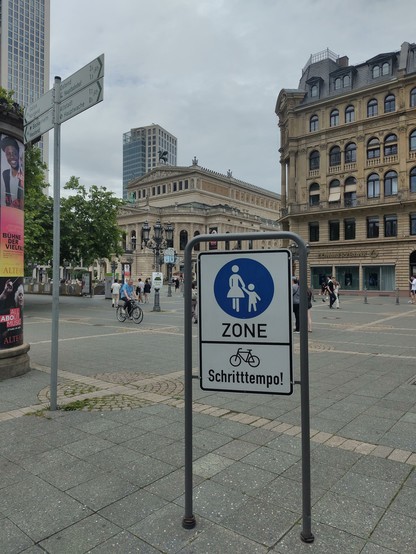 Pedestrian zone in an old town. A sign says that bikes are allowed in walking pace