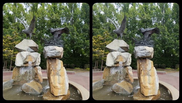 It's a fountain with big, craggy rocks in it, with water cascading down into the pool below. Two pillars of rocks, to be exact, and on top of one is a great, big bronze sculpture of an eagle, while on the other is topped with a nest containing a standing eagle.