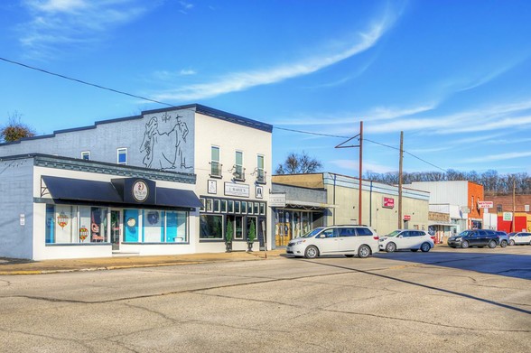Yoakum Street Chaffee Missouri 

A quaint small-town street features several storefronts, including a cafe and bakery, under a bright blue sky.