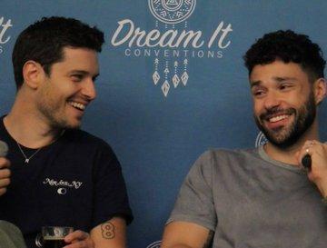 Rafael Silva (Carlos) and Ronan Rubinstein (T.K.) sitting next to each other on stage of the First Responders Reunion Convention V in France. They are laughing and seem happy.