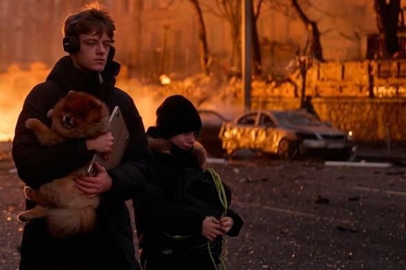 Civilians carry a dog and belongings after a Russian ballistic missile strike on the city center in Kyiv, Ukraine