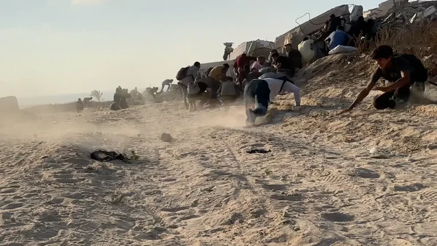 Palästinenser, die westlich von Gaza-Stadt Hilfe suchen, suchen Schutz, als israelische Truppen auf die Menge schießen. Juni 2025. (Screenshot aus einem Video von Abdel Qader Sabbah)