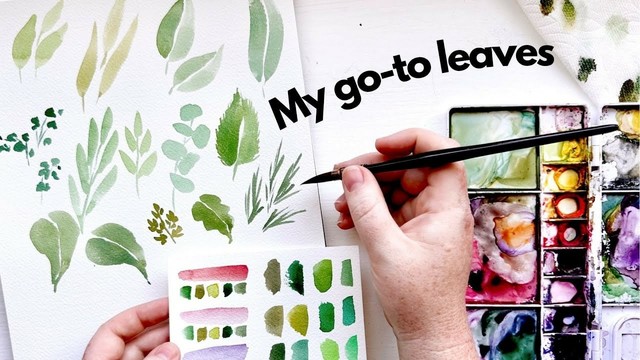A hand holds a watercolor brush over white paper displaying various painted leaf shapes in greens and other colors, with "My go-to leaves" text overlay and a used watercolor palette visible on the right side.