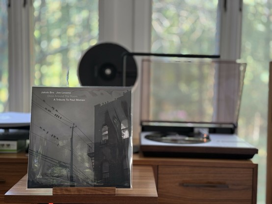 Jakob Bro & Joe Lovano: Once Around the Room - A Tribute to Paul Motian LP cover.

A foggy night, black and white, with a two-story building to the right, and a power line to the left. There are birds on the lines, and other buildings can be seen through the fog.

The black LP plays on a vintage, restored Bang & Olufsen Beogram 4000 linear-tracking turntable to the right.