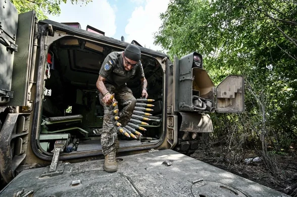 A Bradley IFV crew member of the 47th Mahura Mechanized Brigade carries a belt of munitions on the Zaporizhzhia front line, southeastern Ukraine