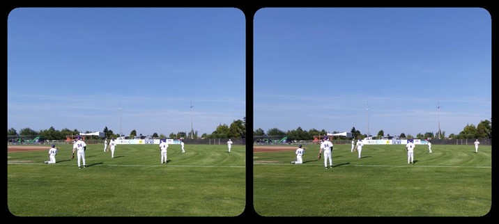 A fence, with baseball players beyond.