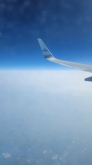 Shot from the window of a KLM plane behind the wing on our way to Prague. Deep blue sky floats above a ground plane of white clouds.