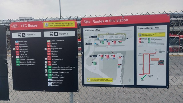 two signs affixed to a fence at a bus platform at Kennedy Station in Toronto. the first sign is the route list of Platform A and Platform B. Platform B has several routes with a mark indicating their route travels express to Scarborough Centre. the second sign shows the routes to each of the 16 bus bays on the platforms, along with a map showing the interim stops of the express service.