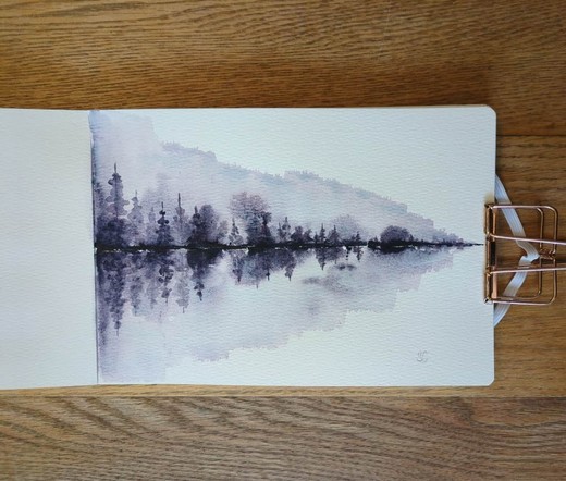 This is a Reflective Atmospheric Watercolor Landscape Painting in landscape orientation in an A5 sketchbook. I used Daniel Smith Moonglow for this art piece because it is made up of three pigments: Veridian, Ultramarine Blue, and Anthraquinoid Red. In masstone the color is a dark smokey cool purple but when it is diluted the blue and red splits out. Along the tree line is Moonglow in masstone then it's diluted above and below the tree line getting bursts of dark and medium value smokey purple; those are diluted further into lighter values and this where the pigment splitting happens. The composition is a horizontally stretched triangle with taller trees on the left getting shorter moving to the right.