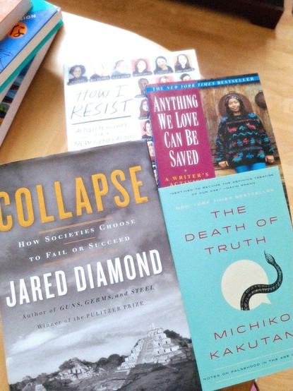 Photo of four books on a wooden table.
Books: Collapse by Jared Diamond; How I Resist;  Anything We Love can be Saved; and The Death of Truth.