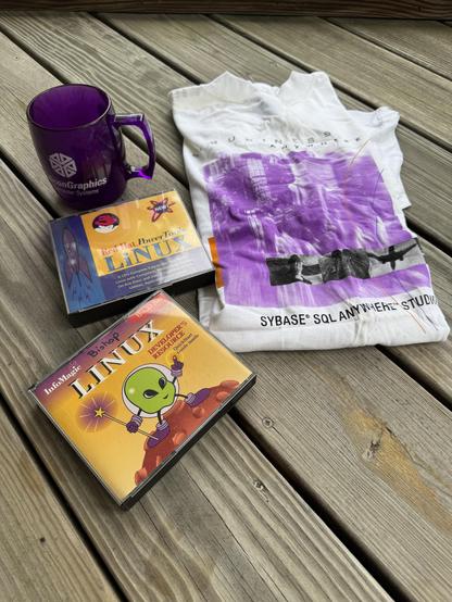 A silicon graphics mug, sybase t-shirt and 2 Linux CDs