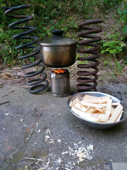 Der Versuch läuft. Unter dem Topf züngelt  eine Flamme aus dem Kocher heraus.