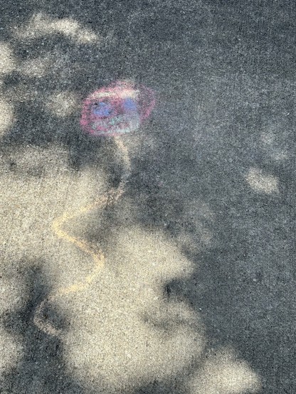 A sidewalk chalk drawing of an angry red balloon for Elon Musk's birthday.