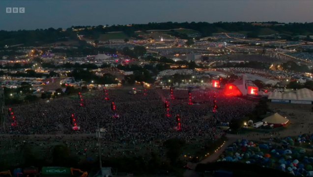 Aerial shot of Glastonbury at sunset with the Pyramid Stage and a _massive_ crowd during Olivia's set