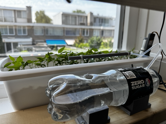 An automatic watering system for my peppers featuring a Pepsi bottle reservoir