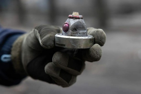 A Ukrainian deminer from the State Emergency Service shows a cluster bomb fragment after a large-scale Russian attack on a residential complex in Dobropillia, Ukraine, in March 2025