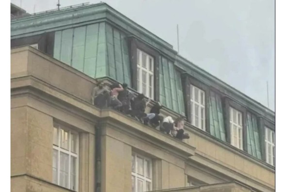 8 Students in Copenhagen? Have climbed out a window to avoid a gunman, and are perched on a ledge hiding.
