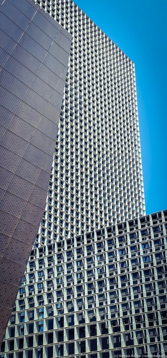 High-rise building of the  University of Luxembourg.  Lots and lots of windows. A small part of a blue sky is visible.