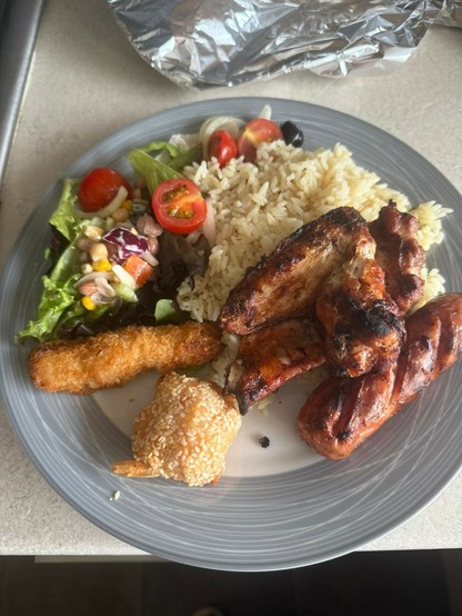 A round plate with rice,salad,BBQ Portuguese sausage and croquette