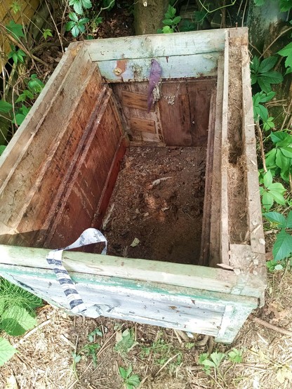 Close-up of the partially disassembled box, showing some of the insulation material in the double-walled side and the hinged back panel partially open. The lid has been removed.