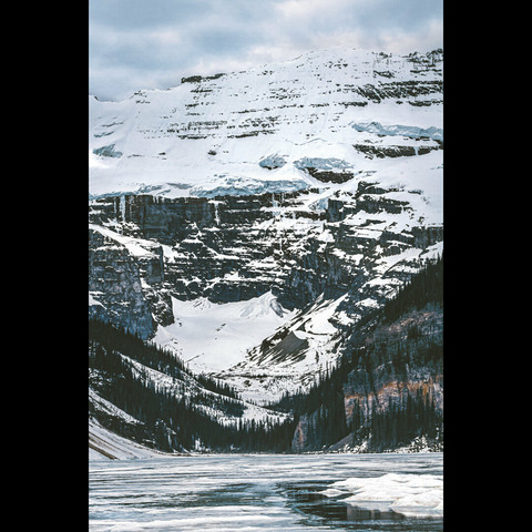 snowy mountains and frozen Louise lake , Alberta, Canada