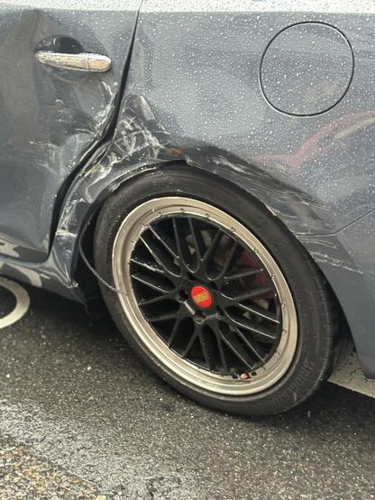 A wrecked blue Mazda‘s door and fender