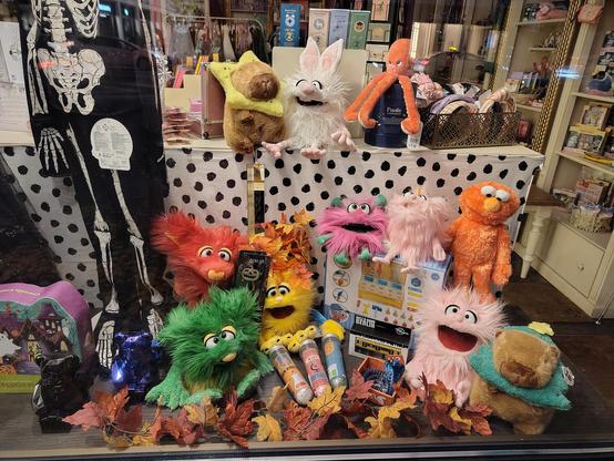 Viele Handpuppen und Kuscheltiere in einem Schaufenster.