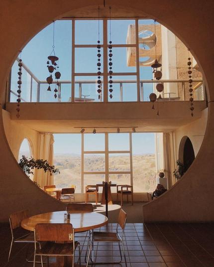 Living room that turns into an open space by a large circled window in the wall