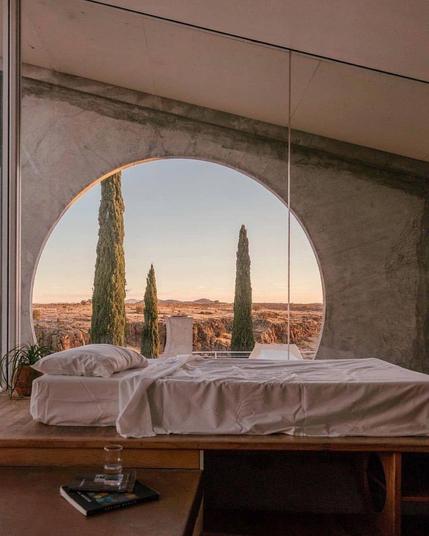 Bedroom with a large circle window with a view to the desert