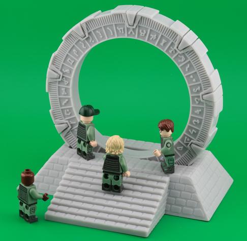 A group of four action figures in military-style outfits interact near a large, circular stone gate with intricate carvings. The background is a vibrant green.

“This gate, …, is plastic”