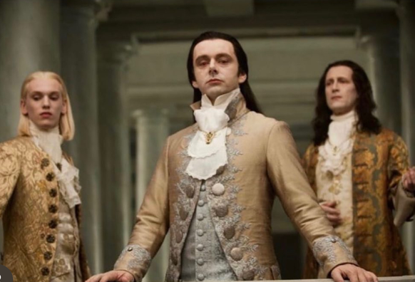 Still from a movie or something showing 3 people dressed in royal-ish 18th century French clothing giving a smug downward look