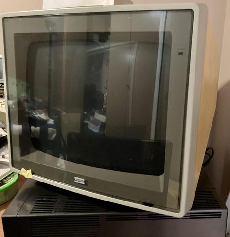 A CRT monitor with an anti-glare cover that is only held on with a piece of masking tape.