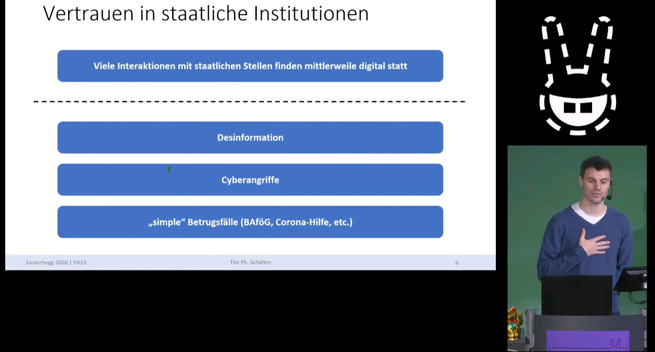 Tim im Vortrag mit Slide zu Vertrauen in staatliche Institutionen
