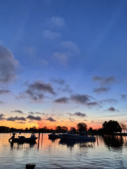 A colorful sunrise over the water. Work Boats in the foreground.