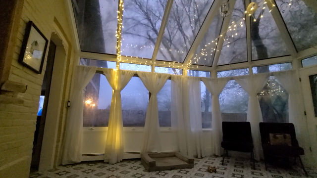 Video in a sun room during a rainstorm. There is a vacant dog bed and an abandoned toy.